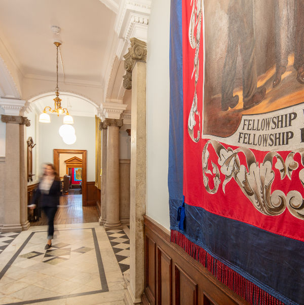 Photo of a corridoor inside redhills with a person walking in the middle and a banner visible to the right.