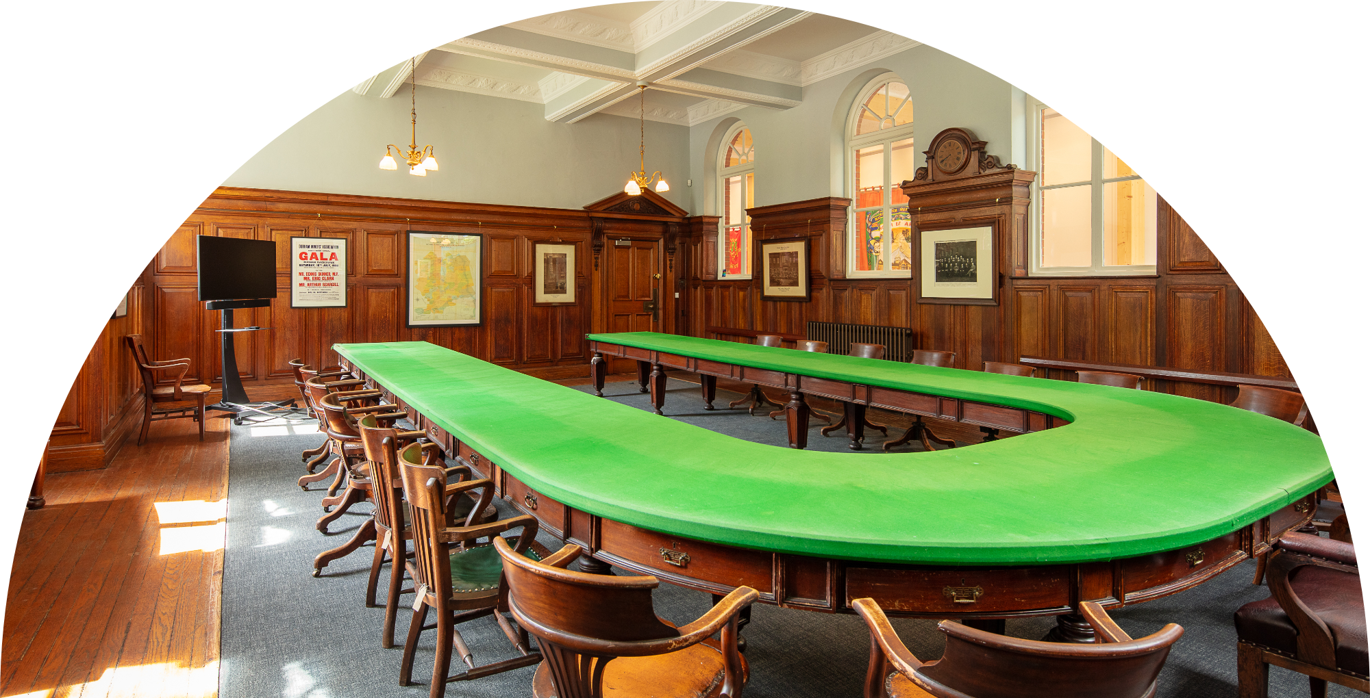 Photo of one of the meeting rooms within Redhills. There's a green felt covered table with chiars all around in a horseshoe shape.